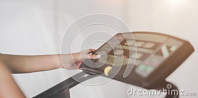 Close-up view of woman adjusting speed while exercising on treadmill at gym Stock Photo