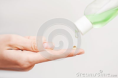 Close up view of woman`s finger with drop of personal antiseptic or sanitizer. Covid-19 protection measures Stock Photo