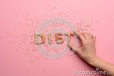 Close-up view of word diet made from sweets and human hand holding letter Stock Photo