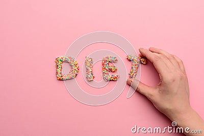 Close-up view of word diet made from sweets and human hand holding letter Stock Photo