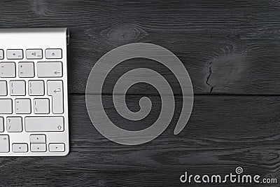 Close up view of a workplace with wireless computer keyboard, keys on old black wooden table background. Stock Photo