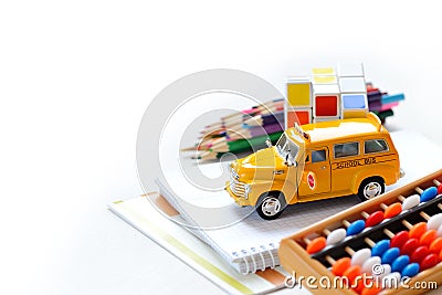 Close up view of yellow bus colorful back to school supplies border over white table. Space for text. Stock Photo