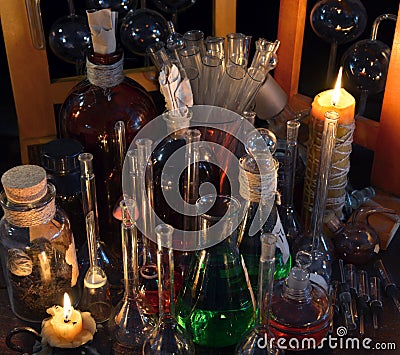 Close up of vintage bottles, flask and candles in alchemy laboratory Stock Photo