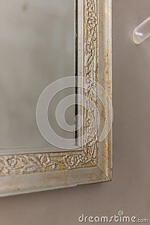 Close-up of a vintage mirror featuring intricate, flower-shaped carvings on the frame Stock Photo