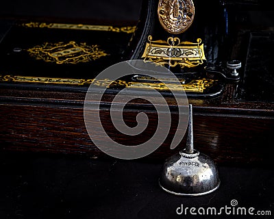 Close up of a vintage Singer sewing machine with original oil can. Editorial Stock Photo