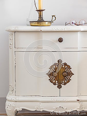 Close-up of vintage wooden bedside table with metal fitment. Candle and glasses for reading for cosy atmosphere. Stock Photo
