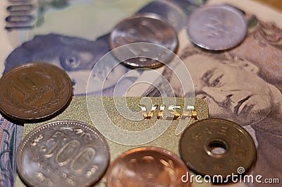 a visa card laying on top of some coins and money Editorial Stock Photo