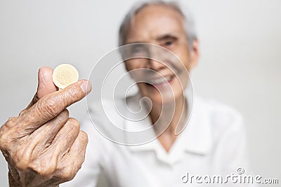 Close up of vitamin C tablets,dietary supplement in hands of elderly,medicine drug for immunity,asian senior woman holding calcium Stock Photo