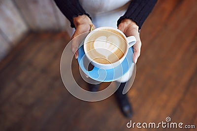 Close Up Of Waitress In Coffee Shop Holding Cup With Heart Design Poured Into Milk Stock Photo