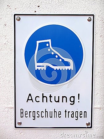 Close up of a warning sign advising people to wear mountain boots Stock Photo