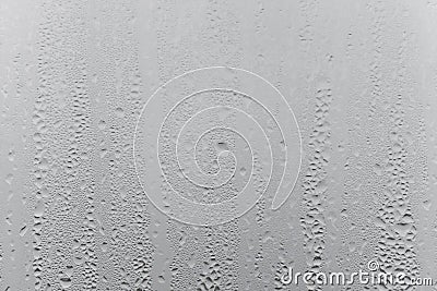 Close up water drop on grey background, misted glass with droplets of water draining down. Dripping Condensation Stock Photo