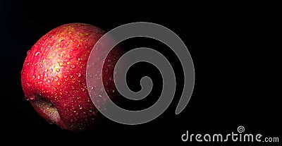 Water droplet on glossy surface of red apple on black background Stock Photo