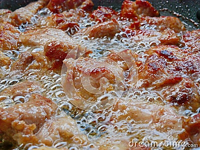 Close up of well-done deep frying pork in boiling / bubbling cooking oil a frying pan - cook at home Stock Photo