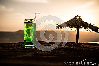 Close up wet glass of green cold mint drink, colorful orange sunset background on the terrace. Cooling summer drink. Summer fresh Stock Photo