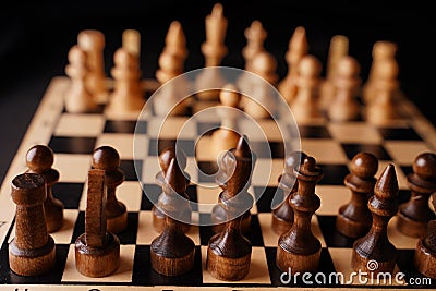 Close up of white and black chess pieces on board. Selective focus on first move of white pawn on chessboard. Concept of Stock Photo