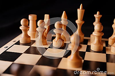 Close up of white and black chess pieces on board. Selective focus on first move of white pawn on chessboard. Concept of Stock Photo