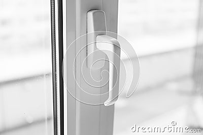 Close-up on a white handle of the pvc window. Stock Photo