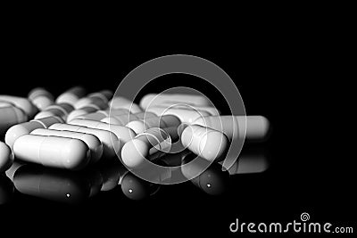 Close up of white painkiller capsule on a reflective black background Stock Photo