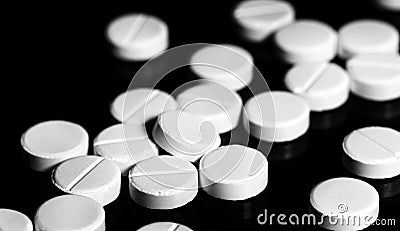 Close up of white painkiller tablet on a reflective black backgr Stock Photo