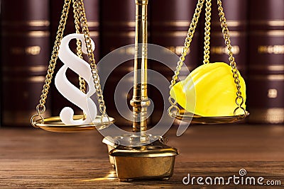 Paragraph Symbol And Hard Hat On Justice Scale Stock Photo