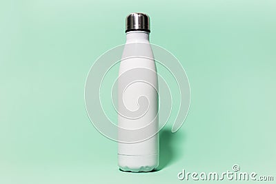 Close-up of white reusable steel stainless thermo water bottle isolated on background of aqua menthe color. Plastic free. Stock Photo