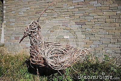 Willow sculpture of Lapwing in front of stone wall Editorial Stock Photo