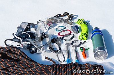 Close-up of winter climbing equipment on fresh snow on a sunny day. Carbines with a rope gazebo and zhumar as well as Stock Photo