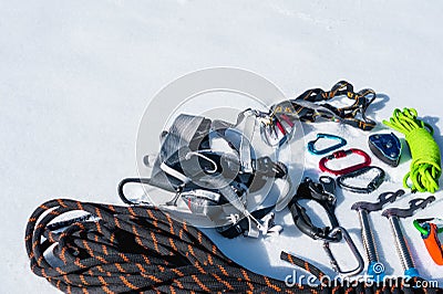 Close-up of winter climbing equipment on fresh snow on a sunny day. Carbines with a rope gazebo and zhumar as well as Stock Photo