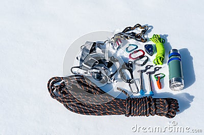 Close-up of winter climbing equipment on fresh snow on a sunny day. Carbines with a rope gazebo and zhumar as well as Stock Photo