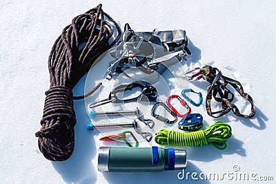 Close-up of winter climbing equipment on fresh snow on a sunny day. Carbines with a rope gazebo and zhumar as well as Stock Photo