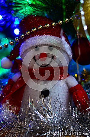 Close-up of a winter white toy snowman with Christmas tinsel in the background Stock Photo