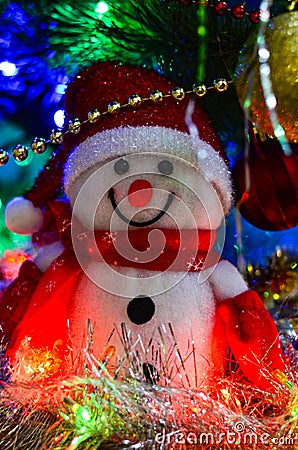 Close-up of a winter white toy snowman with Christmas tinsel in the background Stock Photo