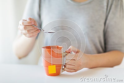 Close up of woman adding sugar to tea cup Stock Photo