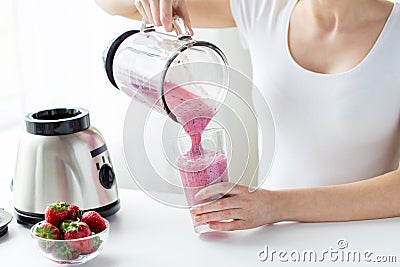 Close up of woman with blender pouring milk shake Stock Photo