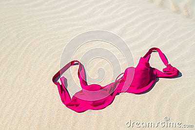 Close up of woman bra at nude beach. Concept of sunbathing naked on the sandy ocean beach. Naturalist lifestyle. Nobody Stock Photo