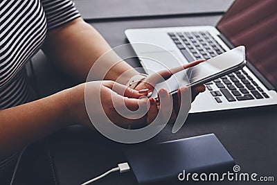 Woman charging mobile phone using power bank Stock Photo