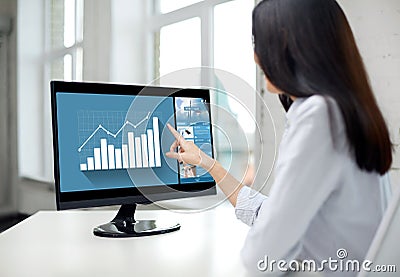 Close up of woman with chart on computer in office Stock Photo