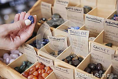 Close Up Of Woman Choosing Healing Crystals In Shop Stock Photo