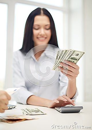 Close up of woman counting money with calculator Stock Photo