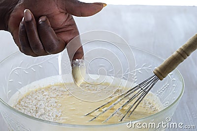 Close-up of woman dipping her finger in the baking Mixture Stock Photo