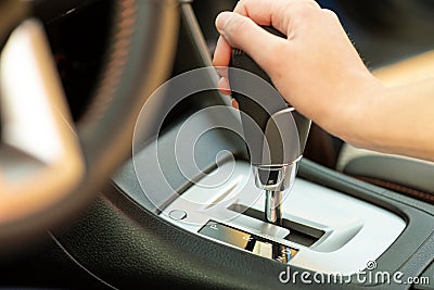 Close up of woman driver holding her hand on automatic gear shift stick driving as car Stock Photo