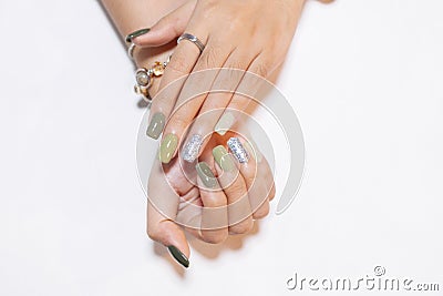 Close up woman fingernail square shape painting beautiful shiny green color pantone gel polish with sparking silver gliitter Stock Photo