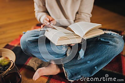 CLose up of Woman freelancer read book sitting in cozy glamping tent in autumn evening. Luxury camping tent for outdoor holiday Stock Photo