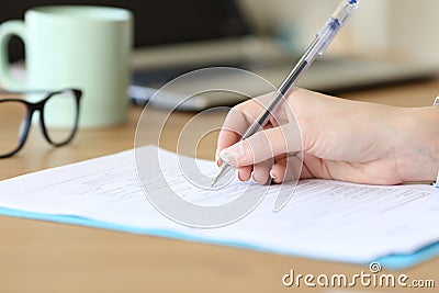 Close up of a woman hand filling form on a table Stock Photo