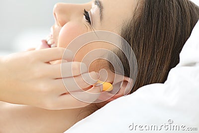 Close up of a woman hand putting ear plugs to sleep Stock Photo