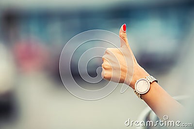 Close-up of a woman hand showing a thumbs-up sign out with car windows Stock Photo