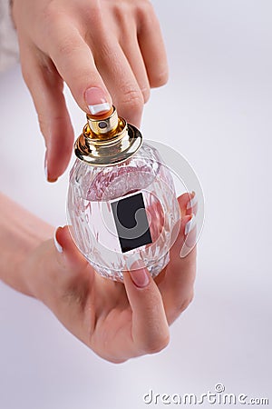 Close up of woman hands spraying perfume. Stock Photo