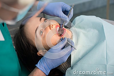 Close up of woman having dental check up in dental clinic. Dentist examining a patient`s teeth with dental tools Stock Photo