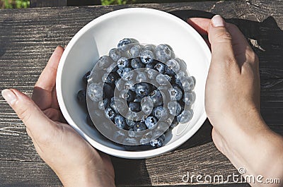 Close up of a woman holding a bowl of blueberries Stock Photo