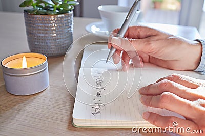 Close Up Of Woman At Home Writing In Gratitude Journal Stock Photo